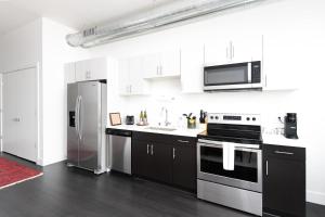 密尔沃基Flexhome Skywalk to Fiserv 1BR Apt U5 - READ INFO的厨房配有白色橱柜和不锈钢冰箱