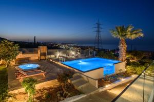 赫索尼索斯Queen's Gem Luxury Villa - Heated Jacuzzi & Pool的一座带游泳池和棕榈树的房子