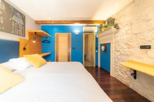特罗吉尔多姆斯马里蒂玛酒店的卧室配有白色的床和蓝色的墙壁
