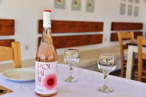 埃拉福尼西岛Rooms Kochilas Elafonisi的一张桌子上放着一瓶葡萄酒,放上两杯