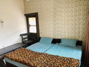 拉瓦尔品第Al-Noor Cottage的一间卧室配有一张床铺,床上有毯子