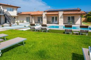 拉齐塞Corte Rocchetti Suite的一座别墅,设有游泳池和绿色草坪