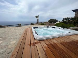 法纳里Villa Elan Fanari的木制甲板上的热水浴池,背面是大海