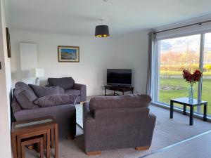 巴拉胡利什Lyn leven cottages的客厅配有两张沙发和一台电视