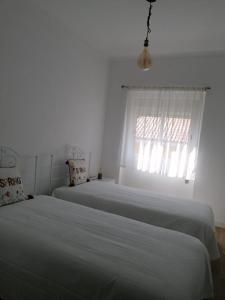 蒙塔吉尔Alojamento Justo - vila de Montargil的白色客房的两张床,设有窗户