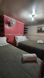 特木科Hostal Las Heras的酒店客房配有两张床和风扇