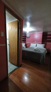 特木科Hostal Las Heras的一间卧室配有一张红色墙壁的床