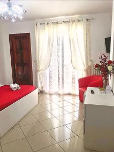 维博瓦伦蒂亚Il Girasole的一间卧室配有红色的床和红色的沙发