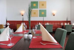 因戈尔施塔特Livenwork Hotel & CoWorking GVZ Ingolstadt的一张桌子,上面放着红餐巾和酒杯