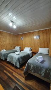 特木科Hostal Las Heras的木墙客房的两张床