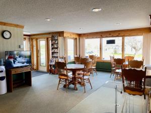 雅茅斯New Age Inn - Voyageur的一间带桌椅和电视的用餐室