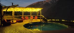 皮斯科艾齐Cabañas "Terrazas de Orión" con Vista Panorámica en Pisco Elqui的甲板上设有热水浴池、椅子和灯