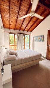 托卢Alquiler casa en la playa, Tolu的一间卧室设有一张带木制天花板的大床