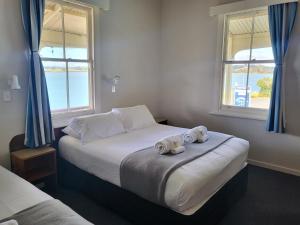 芒奥努伊Mangonui Hotel的一间卧室配有一张大床和毛巾