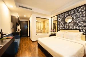 胡志明市Adora Art Hotel的一间带白色大床的卧室和一间浴室