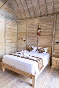 蓝梦岛Coconut Village Guest House Lembongan RedPartner的木制客房内的一间卧室配有两张床