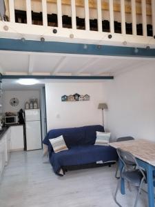 勒卡特Port-Leucate La Grande Bleue的一间带蓝色沙发的客厅和一间厨房