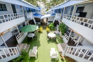 长滩岛Boracay Morning Beach Resort的一个带桌椅和遮阳伞的户外庭院