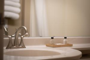 GeringMonument Inn & Suites的浴室配有水槽、餐具和毛巾。