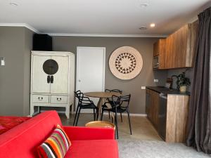 新普利茅斯Escape的客厅配有红色的沙发和桌子