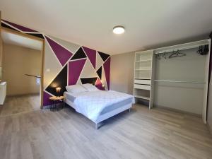 普兰凡Le Gîte du Petit Béret的一间卧室配有一张带彩色墙壁的床