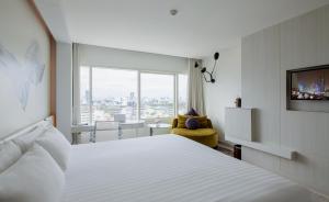 曼谷Centara Watergate Pavilion Hotel Bangkok的一间设有大床和窗户的酒店客房