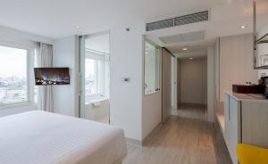 曼谷Centara Watergate Pavilion Hotel Bangkok的酒店客房设有白色的床和电视。