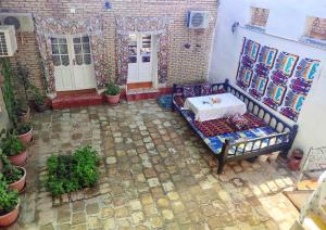 布哈拉Zafar Family Guesthouse的享有带长凳和门的天井的顶部景致