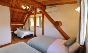 Futoログキャビン伊豆高原的一间带两张床的卧室,位于木天花板的房间