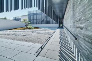 京都MUNI KYOTO by Onko Chishin的建筑的走廊,里面有一棵树