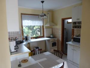 沃尼奥尔茨沃什海吉House Elisabeth Balaton的厨房配有白色橱柜、桌子和窗户。