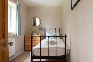 凯尼尔沃思Chase Lodge, Kenilworth, Family Sized Cottage With free Wifi的一间卧室配有黑色床架和镜子