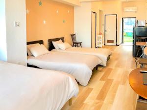 AzamaAzama Ocean View Terrace的酒店客房设有三张床和一张桌子