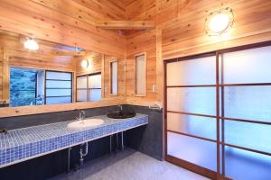 秩父市古民家ー芦ヶ久保的一间带水槽和木墙的浴室