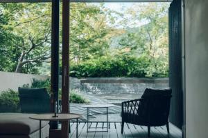京都MUNI KYOTO by Onko Chishin的庭院设有两把椅子、一张桌子和一扇窗户。