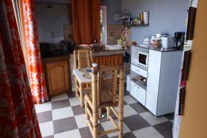 Sainte-SuzanneLa Rond'Dada的厨房配有桌椅和白色冰箱。