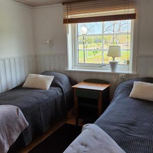 HammarTorpet Gårdsvägen的带窗户的客房内设有两张单人床。