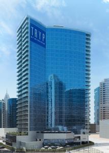 迪拜迪拜温德姆特瑞普酒店的一座高大的蓝色建筑,上面有标志