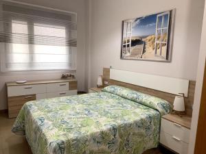阿尔考斯布里Bajo en primera línea de playa的卧室配有一张床,墙上挂着一幅画