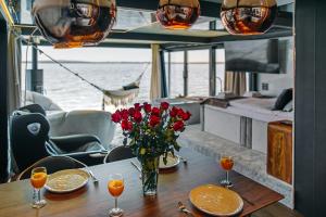 梅尔诺Domki na wodzie - Grand HT Houseboats - with sauna, jacuzzi and massage chair的船上花瓶的桌子