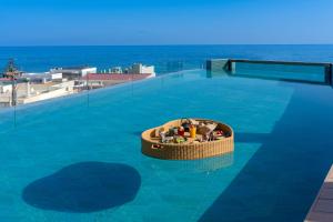 罗希姆诺Minos Ambassador Suites & Spa - Adults only的水中一个圆形的游泳池