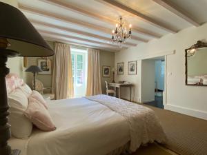 LalindeClos de Bartinquie的卧室配有一张带吊灯的大型白色床。