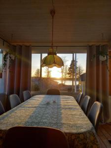 韦特兰达Mysig stuga i naturskönt område.的餐桌、椅子和大窗户