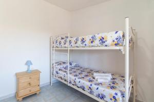 泰斯塔角Michelina的一间卧室设有两张双层床和床头柜。