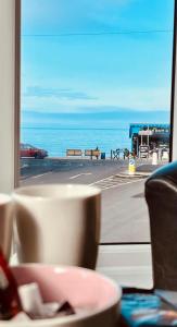 阿伯里斯特威斯gwesTY Guest House的透过窗户欣赏海景,边品杯