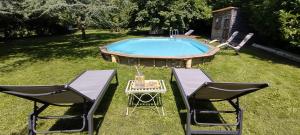 BalsacChateau de Balsac的游泳池畔的两把椅子和一张桌子
