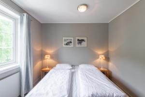 哈山历史酒店的一间白色卧室,配有两张床和两盏灯。