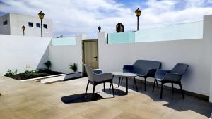 阿雷西费Arrecife exclusive beach house的白色墙壁上配有桌椅的庭院