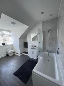 大德里菲尔德Inxpress Luxury Apartment Driffield的白色的浴室设有浴缸和水槽。