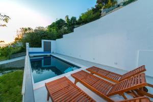 布雷拉Villa Marinkica的一座带游泳池和两个木凳的房子